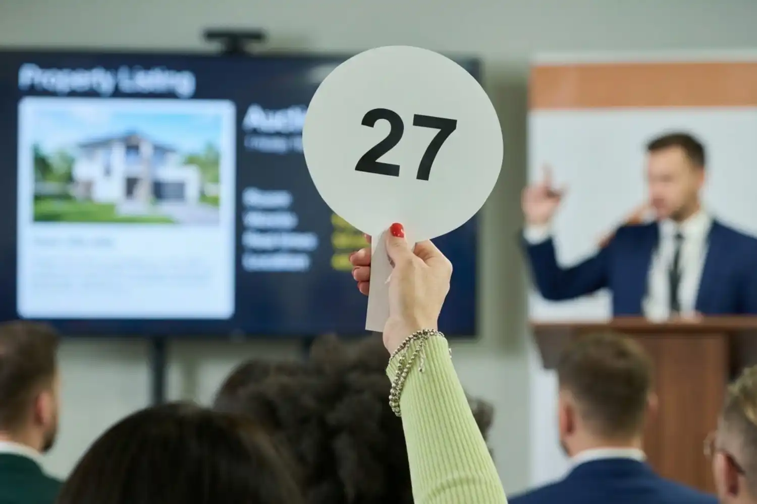 Open bridging loan exit strategy — property buyer at auction raising paddle, planning short-term finance with open bridge before sale